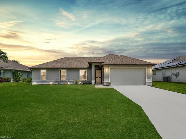 Ranch-style house featuring stucco siding, a shingled roof, an attached garage, and concrete driveway