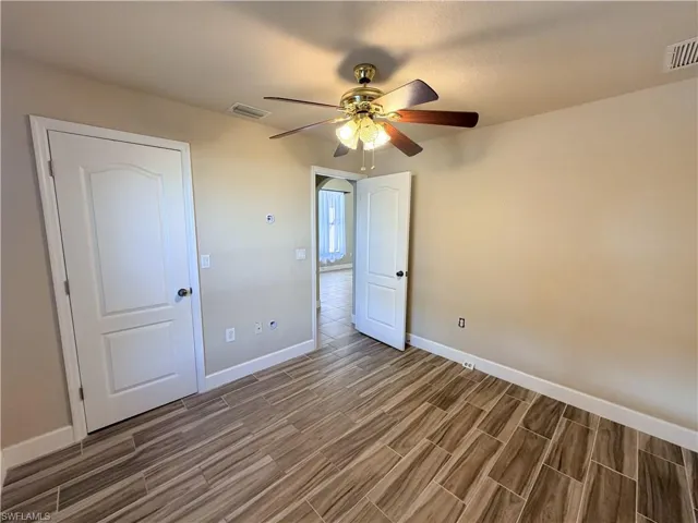Unfurnished bedroom with wood finish floors and a ceiling fan
