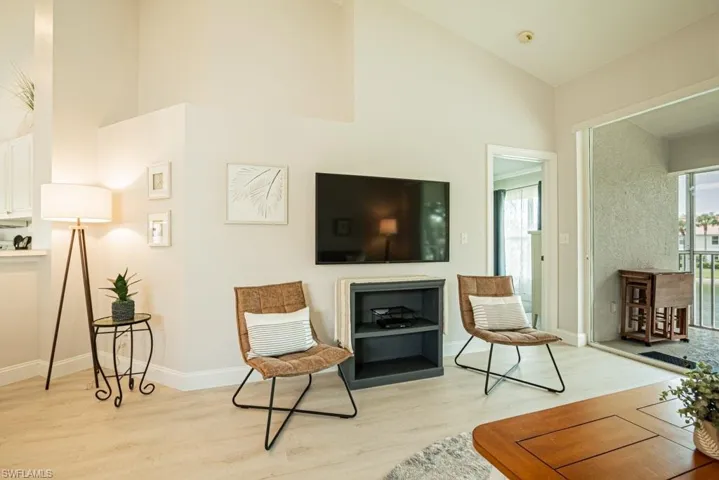 living room with high vaulted ceiling and light wood-type flooring
