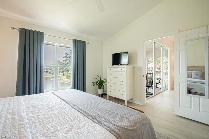 Bedroom featuring light wood-style floors, access to exterior, high vaulted ceiling, and ceiling fan