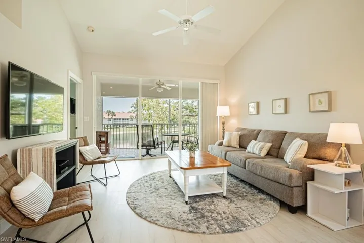 Living room featuring high vaulted ceiling, light wood-type flooring, and ceiling fan