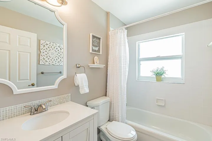 Full bathroom with vanity, toilet, and shower / bathtub combination with curtain