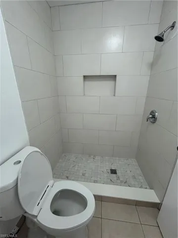 Bathroom with a stall shower and light tile patterned floors