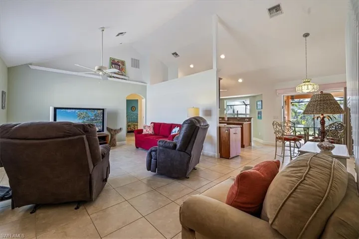 Tiled living room with high vaulted ceiling and ceiling fan