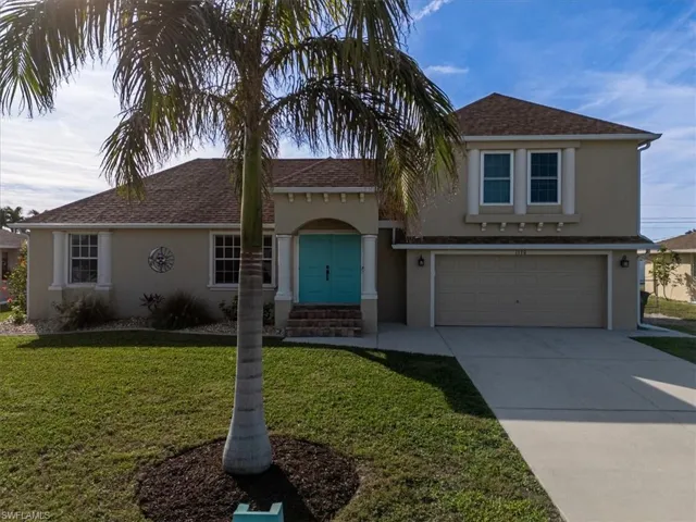 View of front of home featuring a front yard and a garage