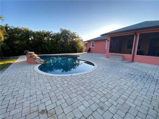 View of swimming pool with a patio area and a sunroom