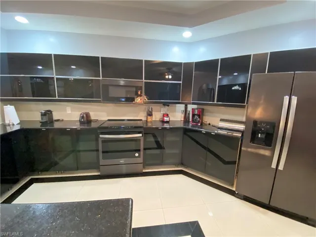 Kitchen featuring light tile patterned floors and stainless steel appliances