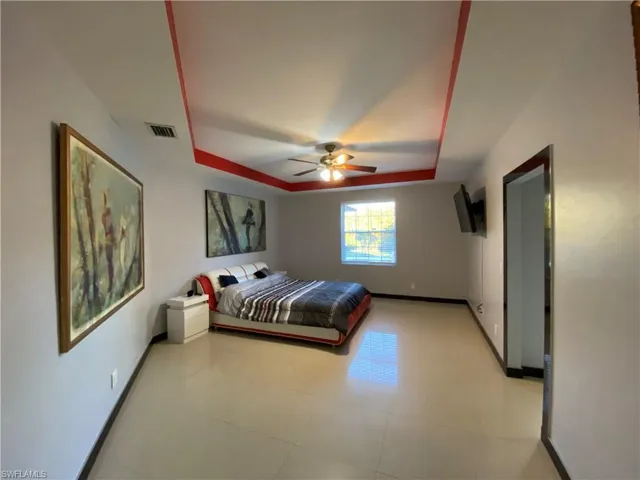 Bedroom with a tray ceiling and ceiling fan