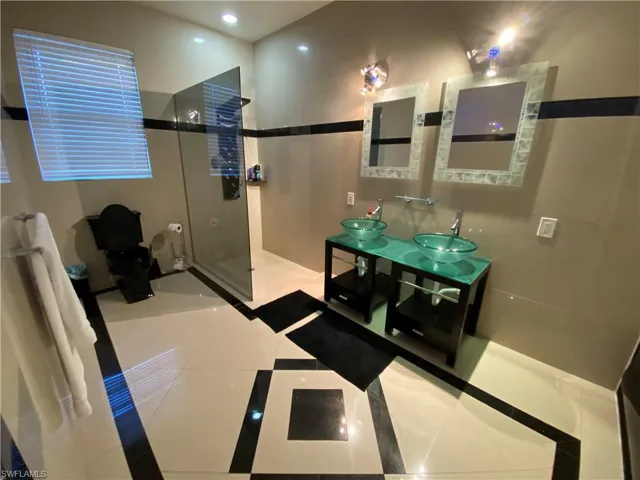 Bathroom with tile patterned flooring, vanity, and walk in shower