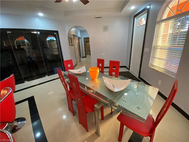 Tiled dining space with ceiling fan and a raised ceiling