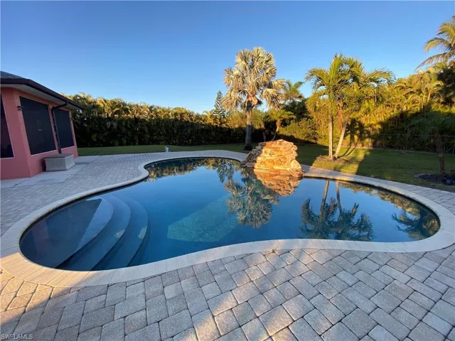 View of pool with a lawn and a patio