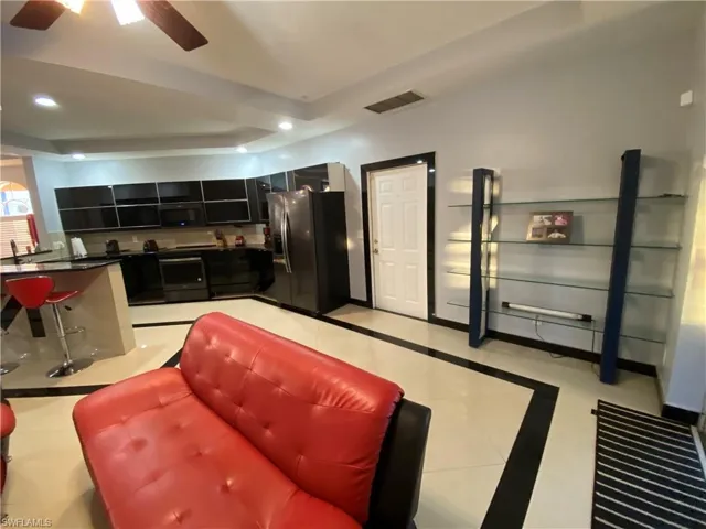 Kitchen featuring ceiling fan, light tile patterned floors, and black appliances