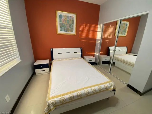 Tiled bedroom with a closet