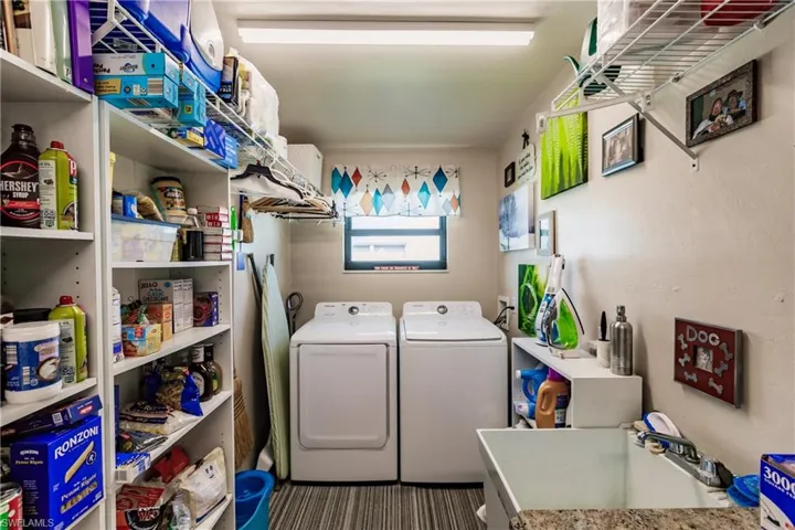 Laundry room with sink, carpet, and washer and dryer