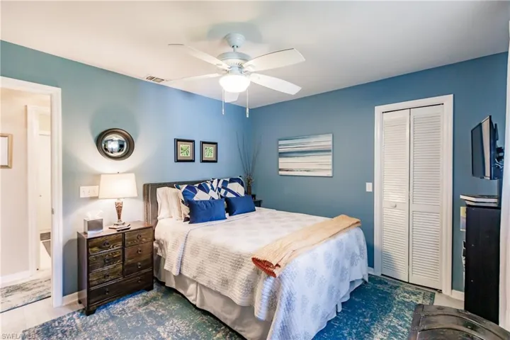 Bedroom with a closet, ceiling fan, and wood-type flooring