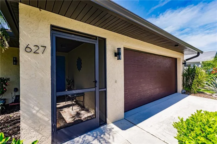 View of screened in entry with double garage