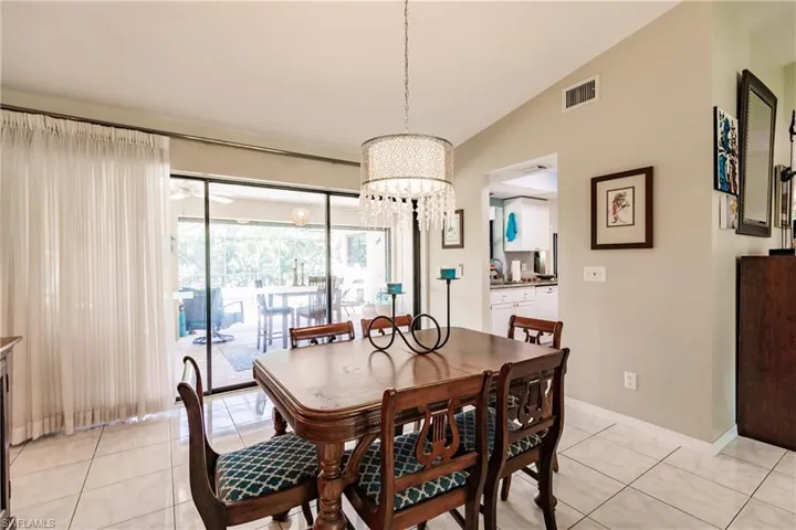 Dining room featuring light tile patterned flooring and vaulted ceiling