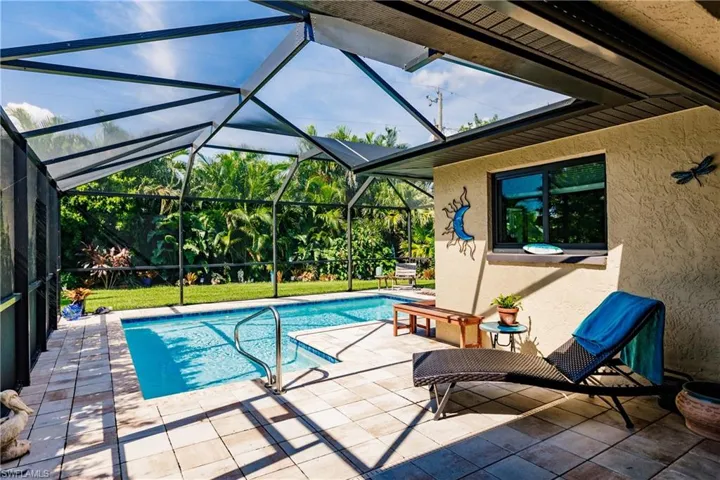 View of pool featuring glass enclosure and a patio