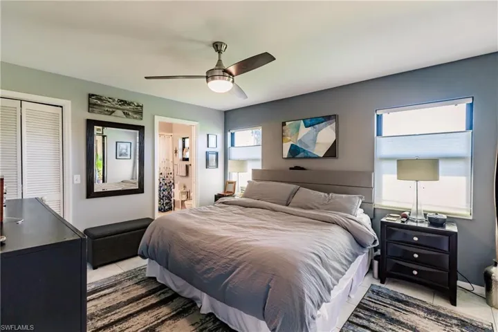 Bedroom with a closet, ceiling fan, and light tile patterned floors
