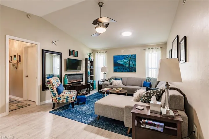 Living room with light hardwood / wood-style flooring and lofted ceiling