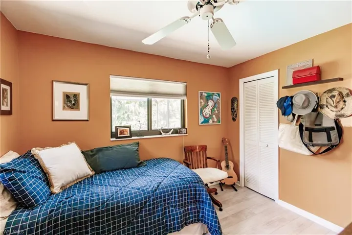 Bedroom with ceiling fan, a closet, and light hardwood / wood-style floors
