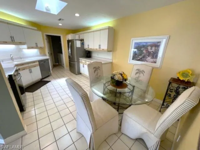 Tiled dining area with a skylight and sink