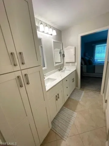 Bathroom with tile patterned floors and double sink vanity