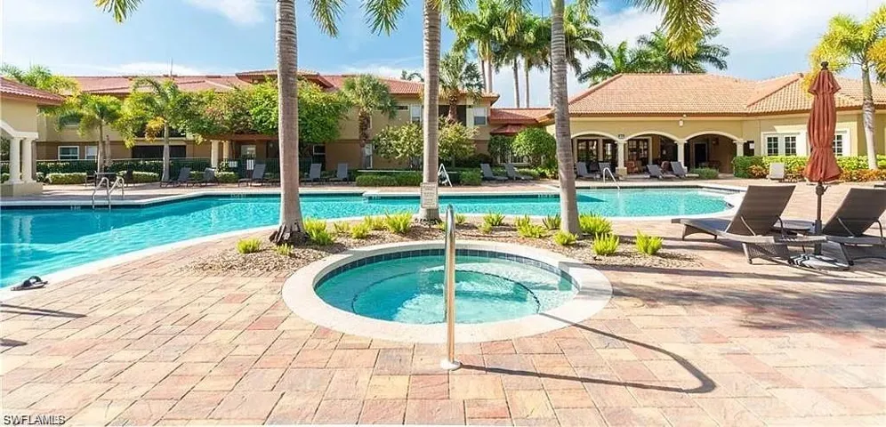 Community pool featuring a patio and a hot tub