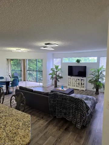 Living room with dark wood-style flooring and a textured ceiling