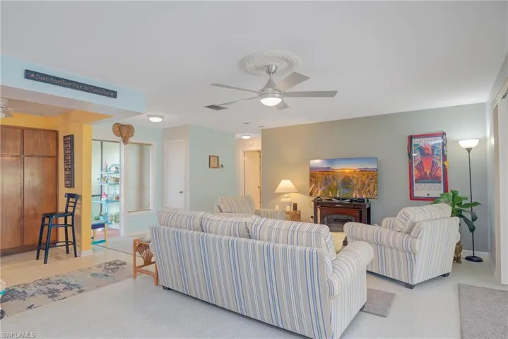 Living area featuring ceiling fan and light carpet