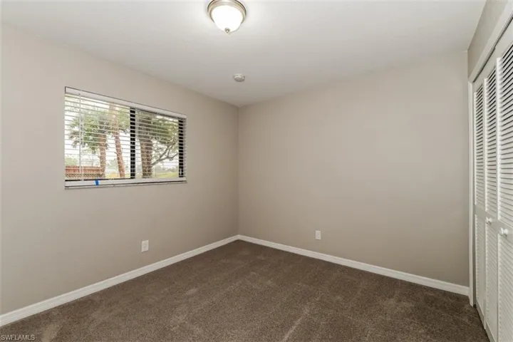 Unfurnished bedroom with dark carpet and a closet