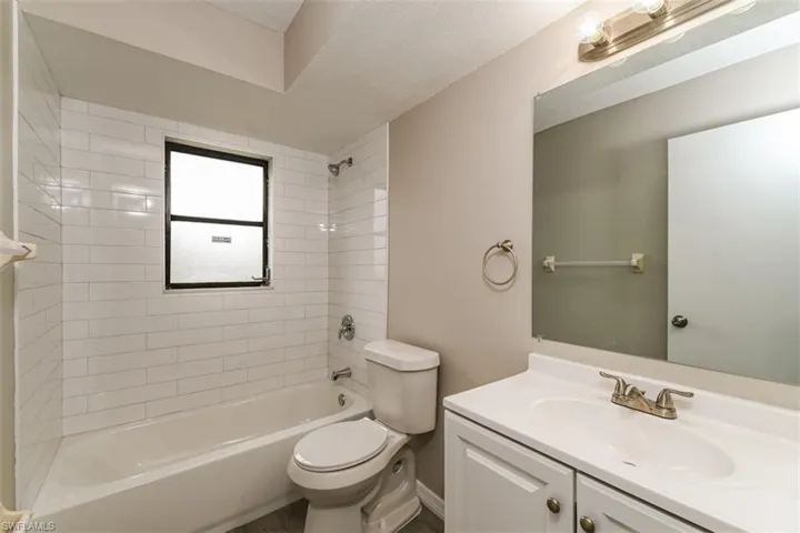 Full bathroom with vanity, tiled shower / bath, and toilet