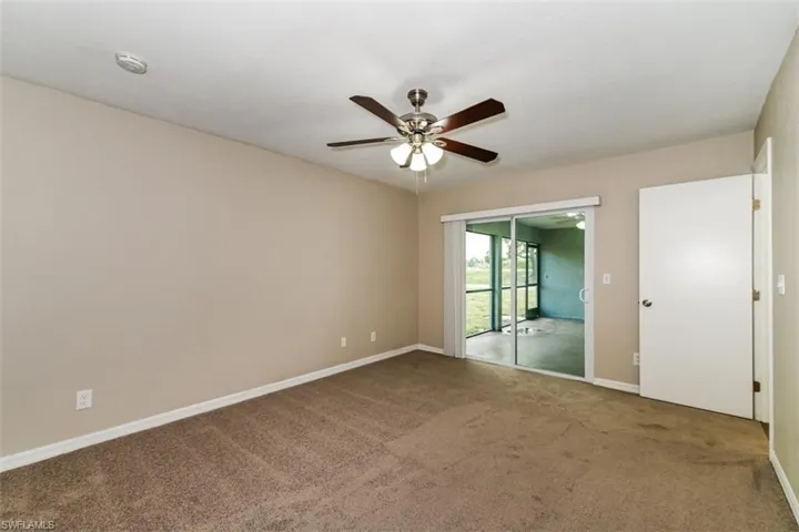 Unfurnished bedroom with carpet flooring, access to outside, and ceiling fan