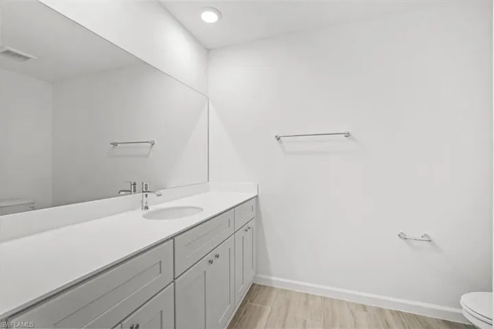 Bathroom featuring vanity, light wood-type flooring, and recessed lighting