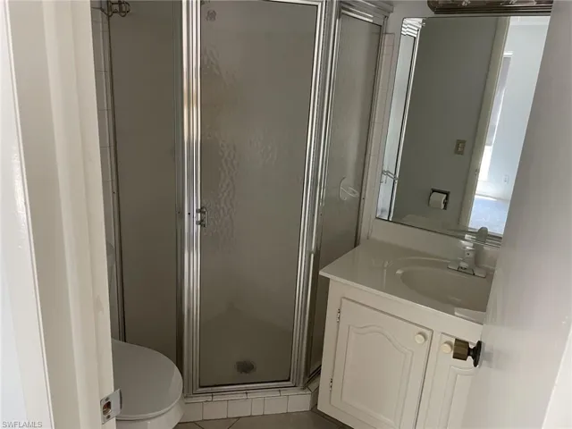 Bathroom with a shower stall, vanity, and light tile patterned floors