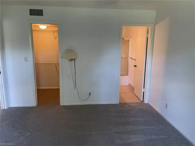 Unfurnished bedroom with a walk in closet and carpet floors