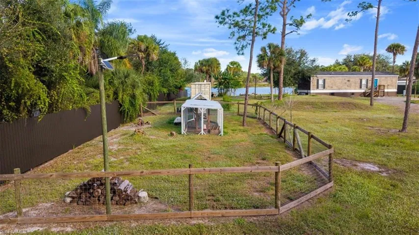 Fenced backyard featuring exterior structure and an outbuilding