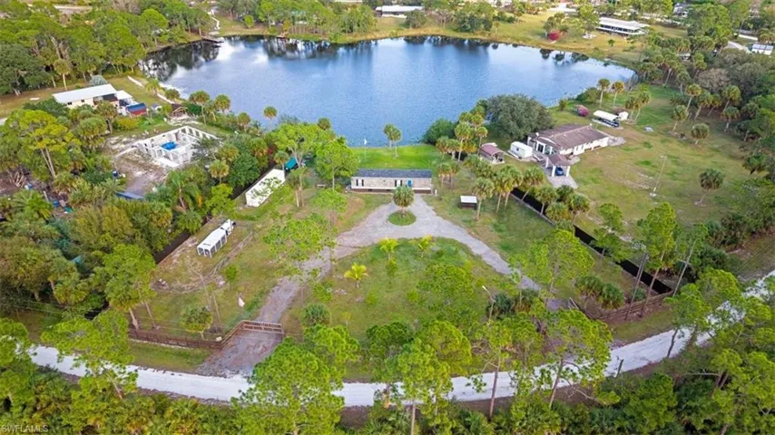 Aerial overview of property's location featuring a large body of water and a tree filled landscape