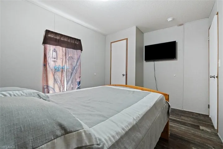 Bedroom with dark wood-style floors and a textured ceiling
