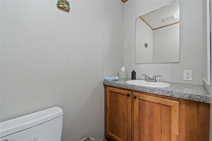 Half bathroom with vanity and toilet
