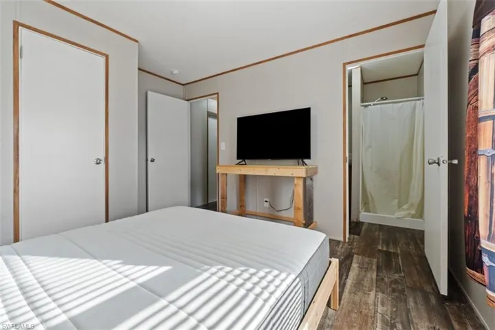 Bedroom featuring ornamental molding and dark wood-style floors