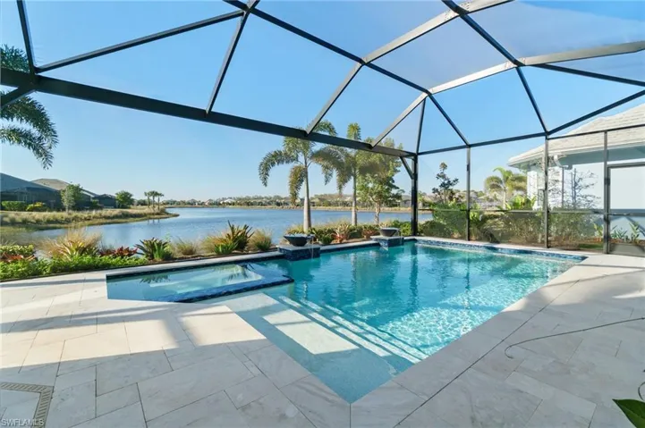 View of pool with a lanai, a patio area, and a water view