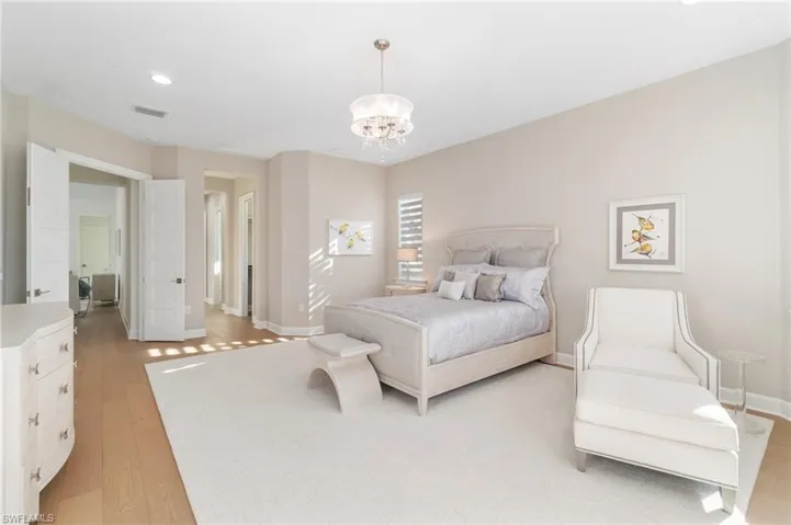 Bedroom with an inviting chandelier and light wood-type flooring