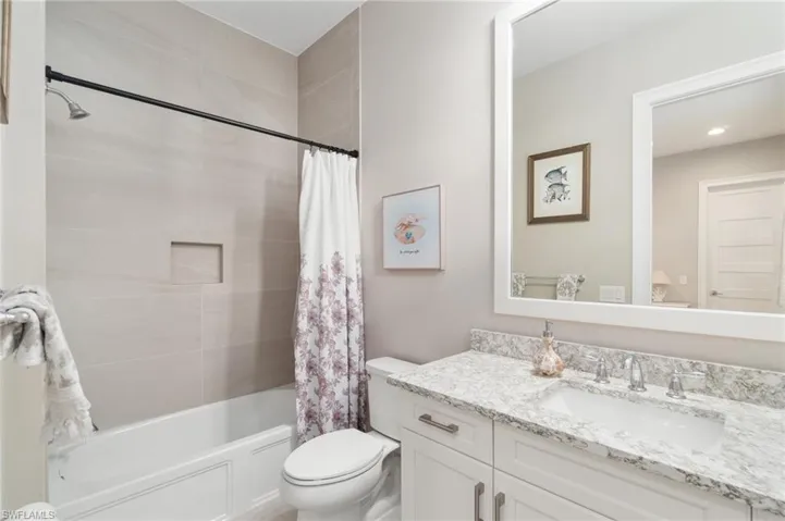 Full bathroom featuring vanity, toilet, and shower / bath combo with shower curtain