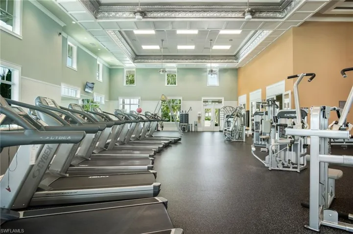 Exercise room with crown molding and a towering ceiling