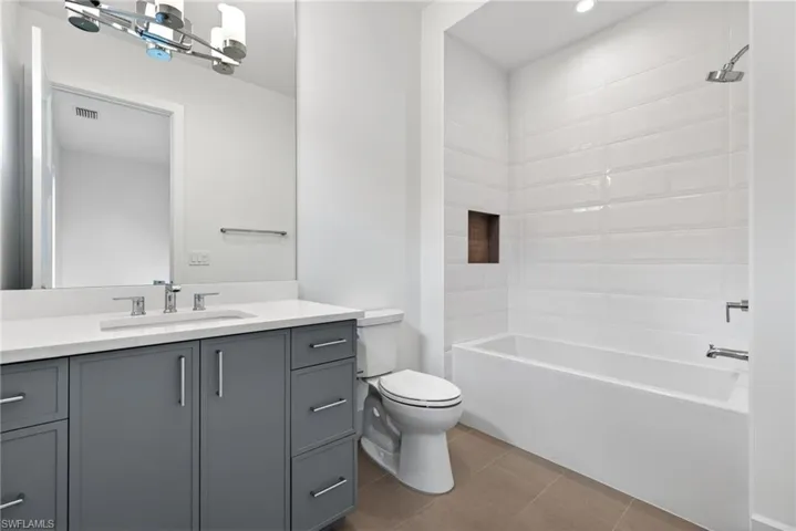 Full bathroom 2 with vanity, tub / shower combination, dark tile patterned floors