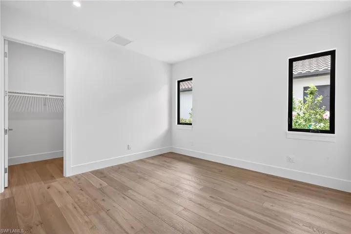 Bedroom 4 features light wood floors , recessed  lighting and walk in closet