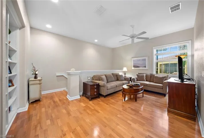 Living area with light wood-style flooring, ceiling fan, and recessed lighting