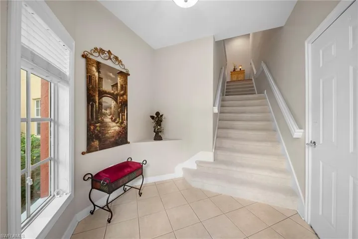 Stairway with tile patterned floors and baseboards