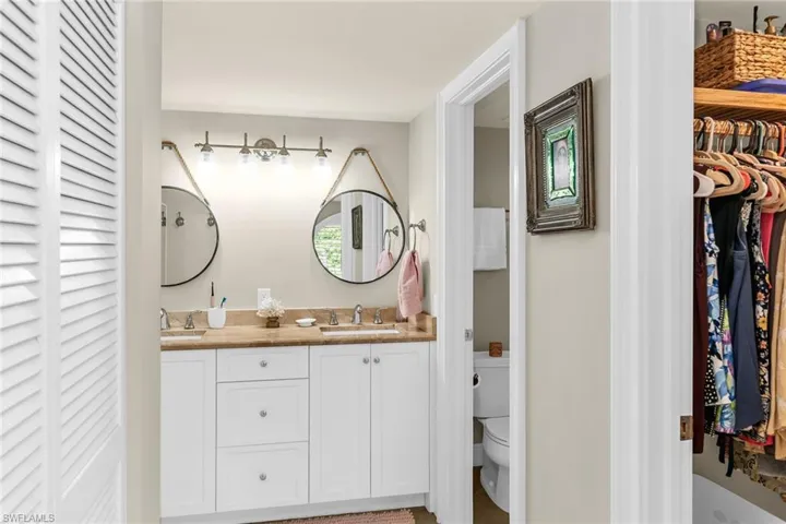 Full bathroom featuring toilet and double vanity